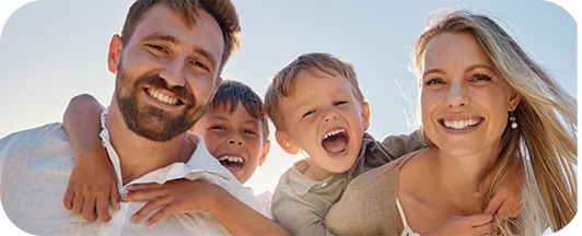 family of four smiling outdoors